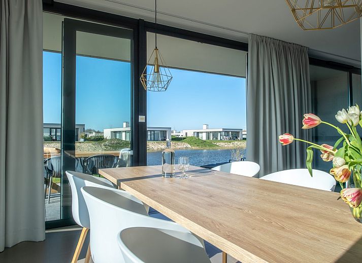 Lichte woonkamer in Waterlijn 03 | De Groote Duynen, vakantiehuis in Kamperland, Noord-Beveland, Zeeland met uitzicht op tuin.