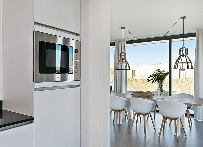 Lichte woonkamer in Waterlijn 03 | De Groote Duynen, vakantiehuis in Kamperland, Noord-Beveland, Zeeland met uitzicht op tuin.