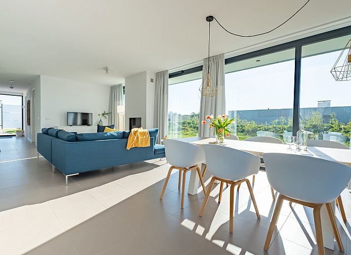 Lichte woonkamer in Waterlijn 03 | De Groote Duynen, vakantiehuis in Kamperland, Noord-Beveland, Zeeland met uitzicht op tuin.