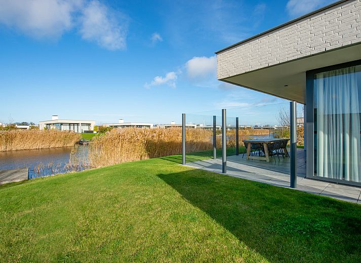 Open leefruimte in Waterlijn 03 | De Groote Duynen, vakantiehuis in Kamperland, Noord-Beveland, met veel lichtinval.