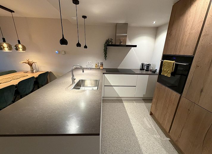 Gezellige woonkamer van vakantiehuis Havenweg 24 in Kamperland, Zeeland, met uitzicht op de natuur en een stijlvolle eetruimte.