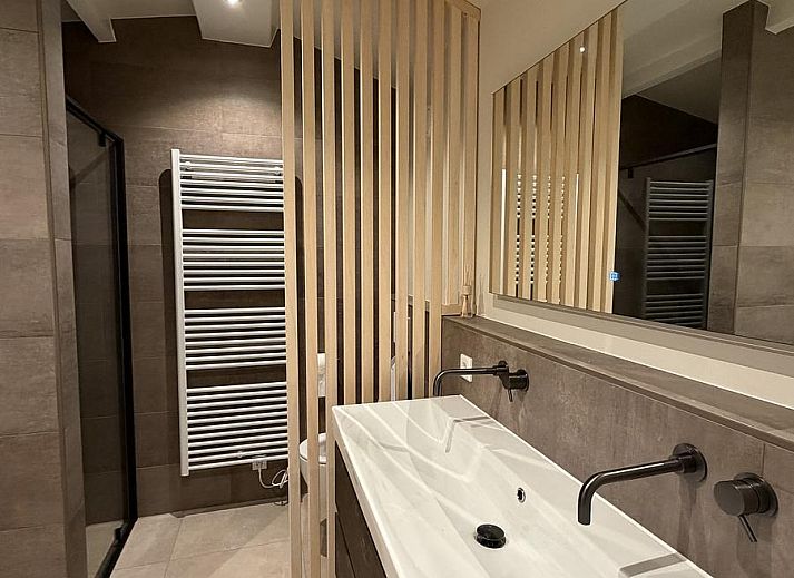 Gezellige woonkamer van vakantiehuis Havenweg 24 in Kamperland, Zeeland, met uitzicht op de natuur en een stijlvolle eetruimte.