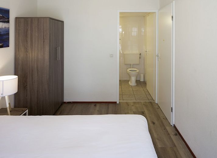 Geraeumiges Wohnzimmer des Bungalows FV14 in Kamperland, Noord-Beveland, Zeeland mit bequemer Sitzecke und grossem Fenster mit Blick in die Natur.