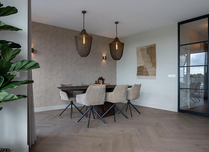 Gezellige lounge in Penthouse Veerweg 173, Kamperland met glazen schuifdeuren en uitzicht op de natuur in Port Elisabeth, Zeeland.