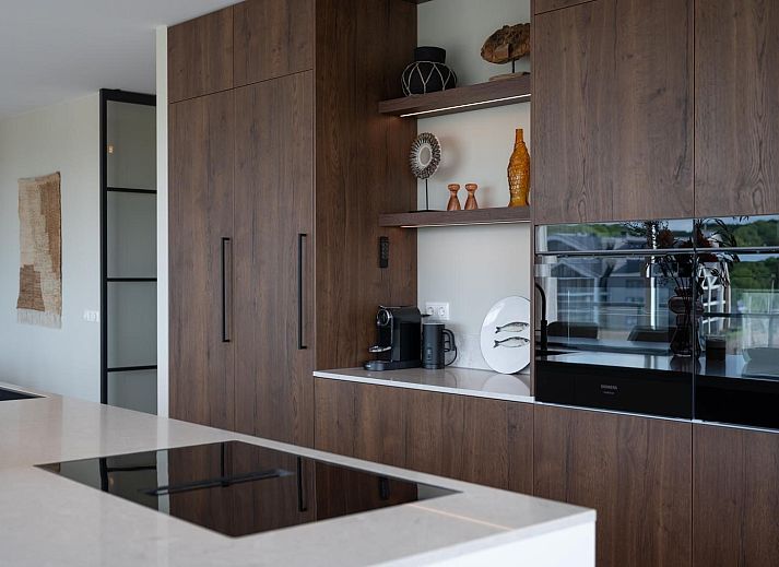 Gezellige lounge in Penthouse Veerweg 173, Kamperland met glazen schuifdeuren en uitzicht op de natuur in Port Elisabeth, Zeeland.