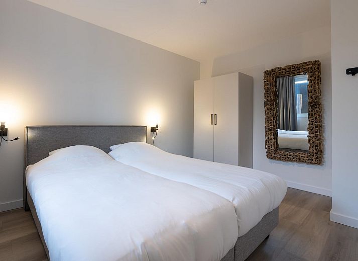 Moderne zithoek in vakantiehuis Harbour Loft 1E, Noord-Beveland, met uitzicht op zeilboten.