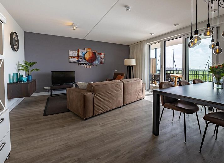 Moderne eetkamer in Harbour Loft 2D, Kamperland, met stijlvolle verlichting en spiegelwand.