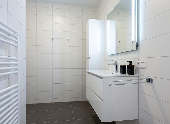 Lichte woonkamer in Harbour Loft 2D, Kamperland, met kunst aan de muur en uitzicht op het terras.