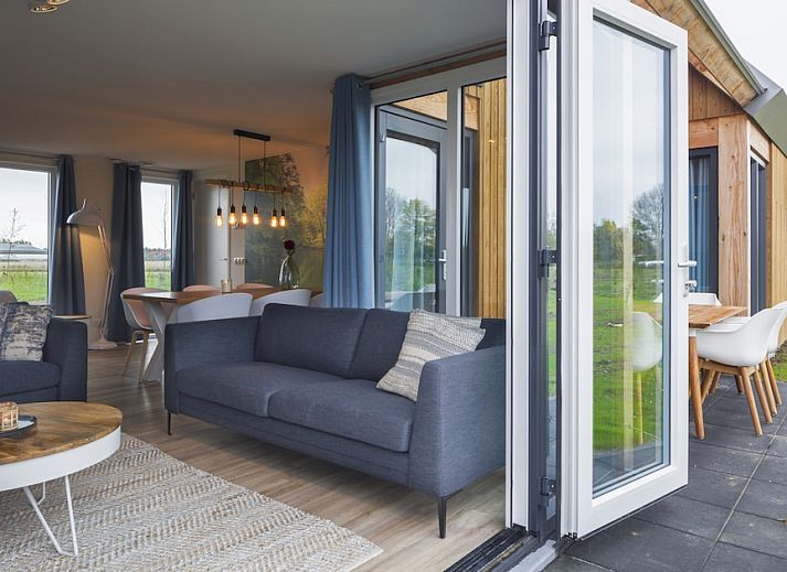 Villa Keats 6, een modern vakantiehuis in Kamperland, Noord-Beveland, Zeeland, omgeven door prachtige tuinen en een ruime veranda.