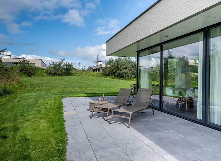 Esszimmer in Duinvallei 09, Ferienhaus in Kamperland, Zeeland, mit grossem Tisch und Blick auf die gruene Umgebung.