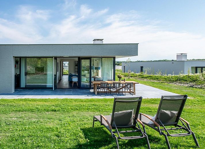 Esszimmer in Duinvallei 09, Ferienhaus in Kamperland, Zeeland, mit grossem Tisch und Blick auf die gruene Umgebung.