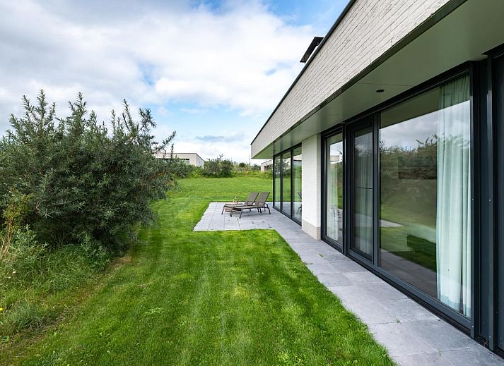 Esszimmer in Duinvallei 09, Ferienhaus in Kamperland, Zeeland, mit grossem Tisch und Blick auf die gruene Umgebung.