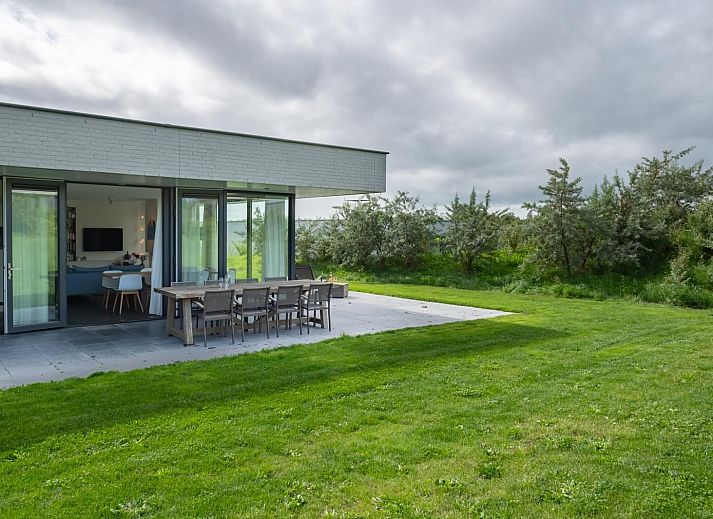 Esszimmer in Duinvallei 09, Ferienhaus in Kamperland, Zeeland, mit grossem Tisch und Blick auf die gruene Umgebung.