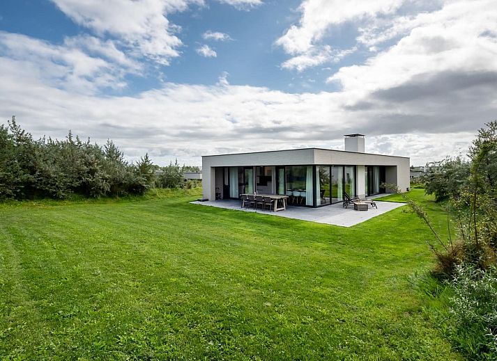 Modernes Wohnzimmer von Duinvallei 09, Ferienhaus in De Groote Duynen, Kamperland, mit Kamin und Gartenblick.