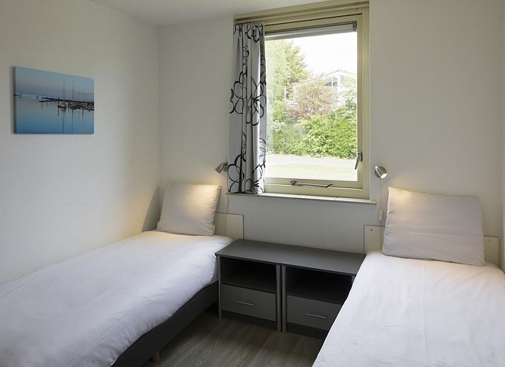 Modernes Wohnzimmer im BD-Bungalow, Kamperland, mit Blick auf die gruene Umgebung.