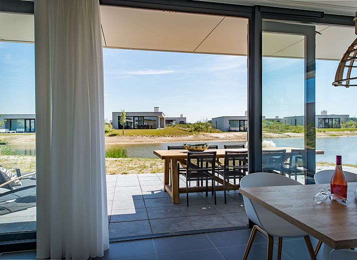 Modernes Esszimmer in der Zandbank 18 | De Groote Duynen, Kamperland, mit Blick auf Natur und Wasser.