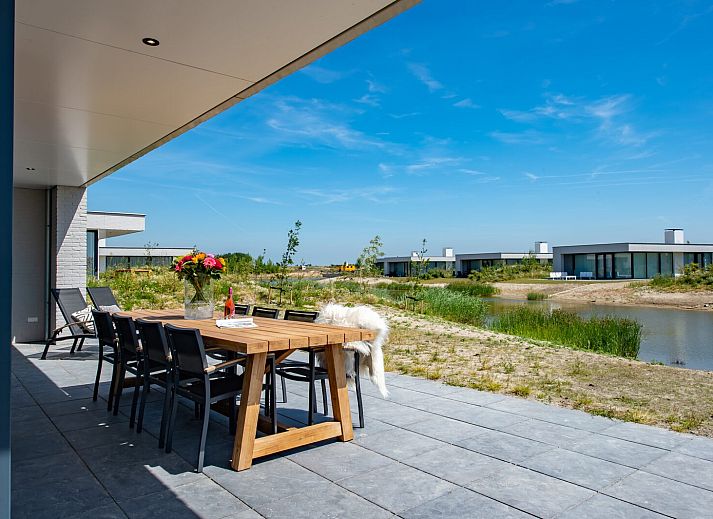 Aussenansicht von Sandbank 18 | De Groote Duynen, Kamperland, mit Wasser und gruener Umgebung.