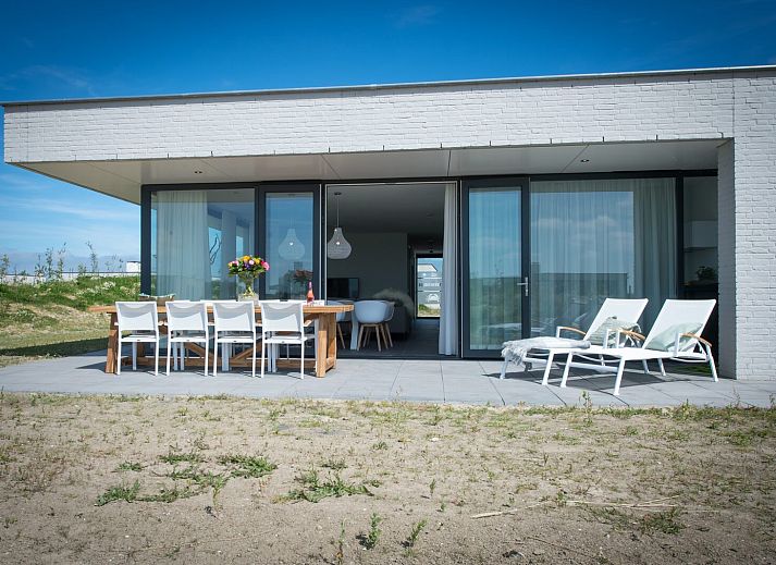 Lichte woonkamer in Zandbank 14, De Groote Duynen, Kamperland, met moderne inrichting en uitzicht op de natuur.