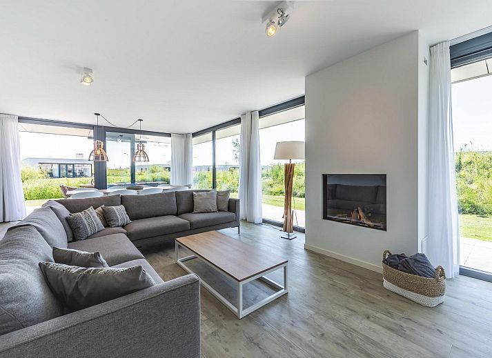 Stilvolles Wohnzimmer in Duinvallei 08, einem Ferienhaus in Kamperland, Noord-Beveland, mit Blick auf die gruene Umgebung.