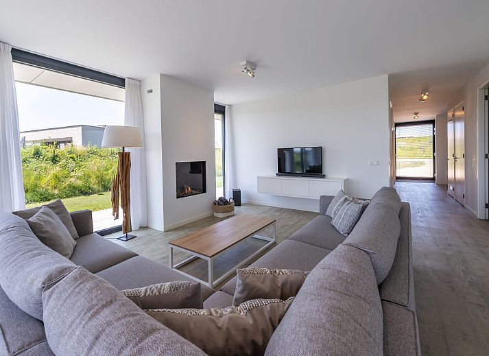 Stilvolles Wohnzimmer in Duinvallei 08, einem Ferienhaus in Kamperland, Noord-Beveland, mit Blick auf die gruene Umgebung.