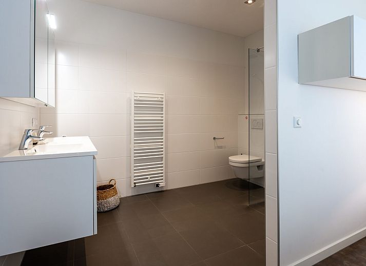 Ruime woonkamer van Waterlijn 28, vakantiehuis in Kamperland, Zeeland met grote ramen.