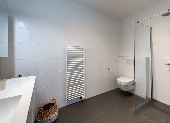 Ruime woonkamer van Waterlijn 28, vakantiehuis in Kamperland, Zeeland met grote ramen.