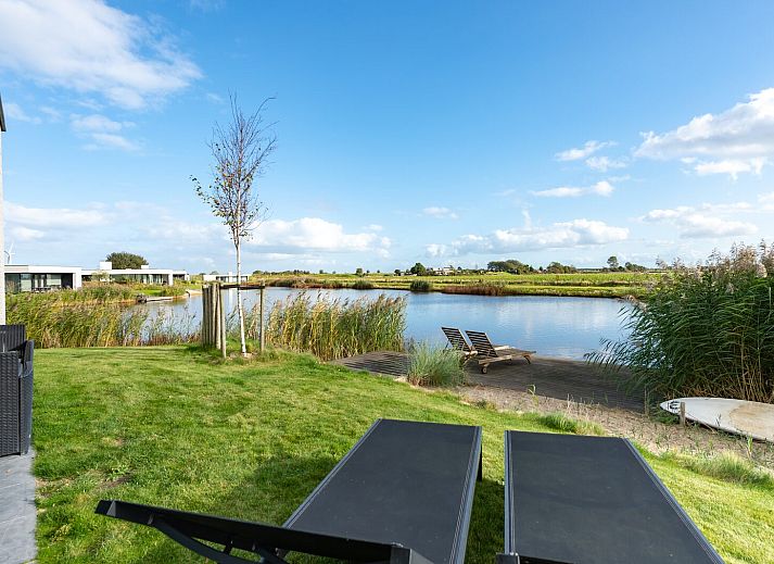 Ruime woonkamer van Waterlijn 28, vakantiehuis in Kamperland, Zeeland met grote ramen.