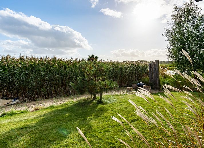 Ruime woonkamer van Waterlijn 28, vakantiehuis in Kamperland, Zeeland met grote ramen.