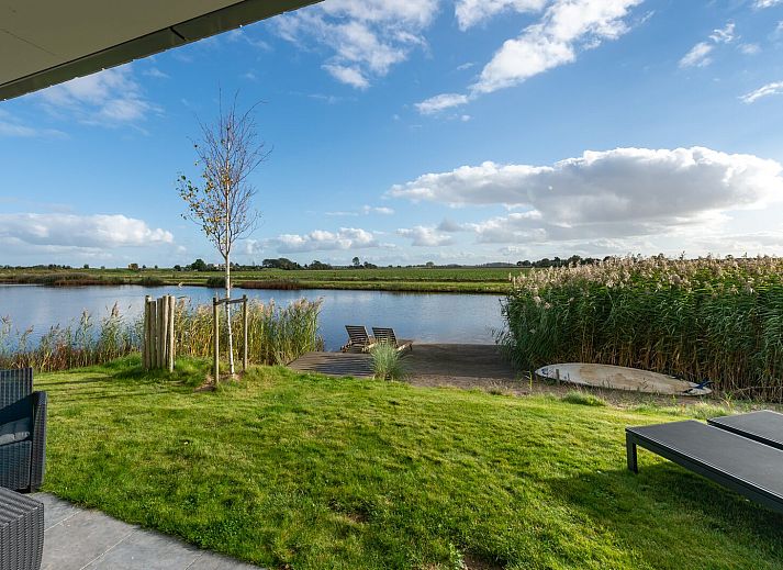 Ruime woonkamer van Waterlijn 28, vakantiehuis in Kamperland, Zeeland met grote ramen.