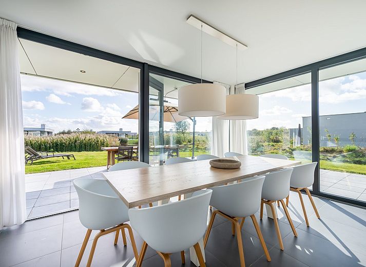 Dining room overlooking garden in Duinvallei 06, vacation home in Kamperland, North Beveland, Zeeland.