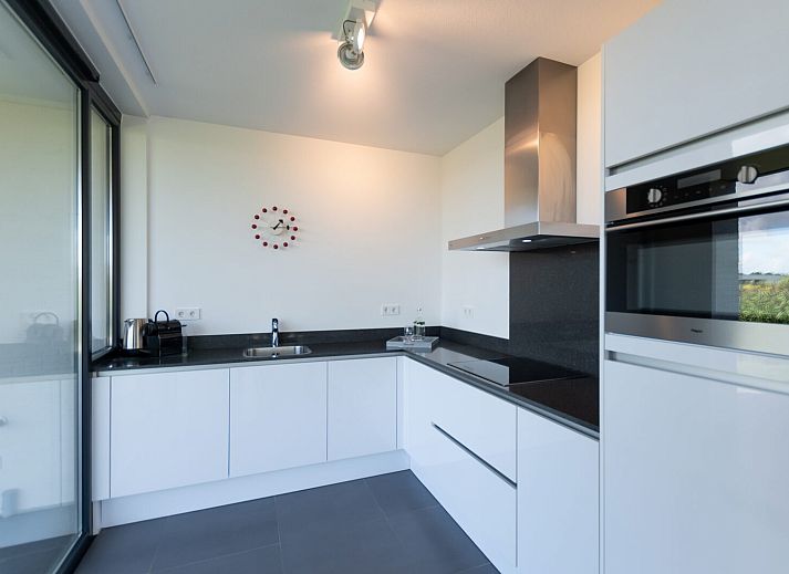 Stijlvolle zithoek met uitzicht op tuin in Waterlijn 05 bungalow, Kamperland, Zeeland.