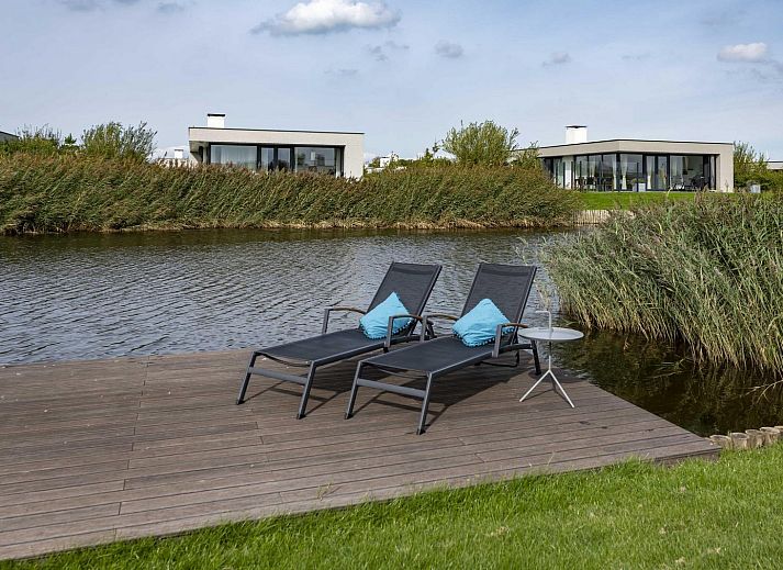 Lichte woonkamer met comfortabele bank in Waterlijn 05 bungalow, Zeeland.