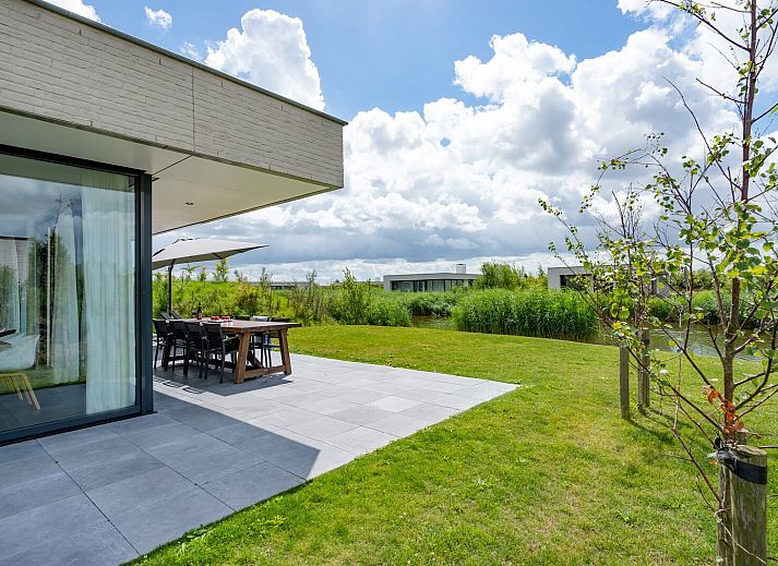 Relax on the veranda of Duinvallei 10 | De Groote Duynen in Kamperland, a luxury vacation home surrounded by the tranquility of Zeeland.