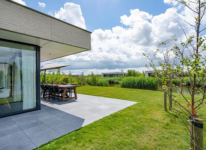 Relax on the veranda of Duinvallei 10 | De Groote Duynen in Kamperland, a luxury vacation home surrounded by the tranquility of Zeeland.