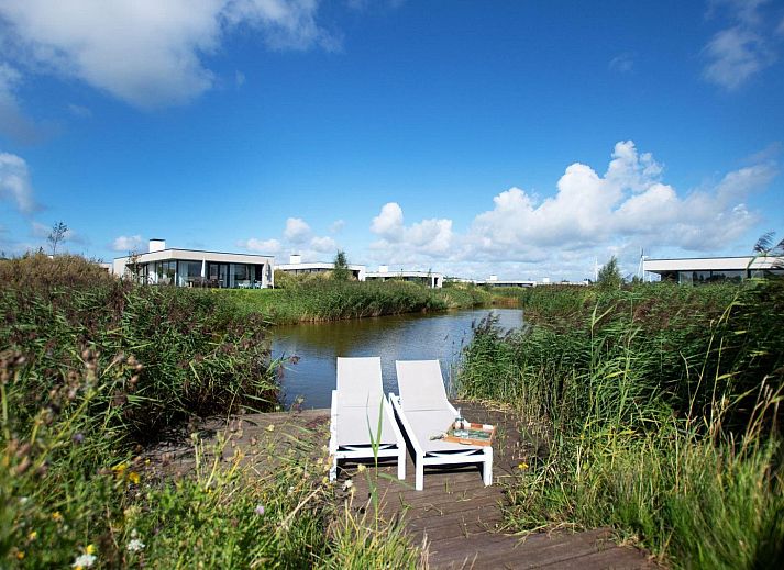 Stimmungsvolle Kerzen im Ferienhaus Zandbank 11 | De Groote Duynen, Kamperland, mit einem warmen Kamin im Hintergrund.
