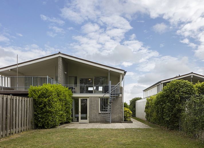 Gemuetliches Wohnzimmer im Bungalow BE, Kamperland, Noord-Beveland, Zeeland mit geraeumiger Sitzecke und Blick auf die gruene Umgebung.