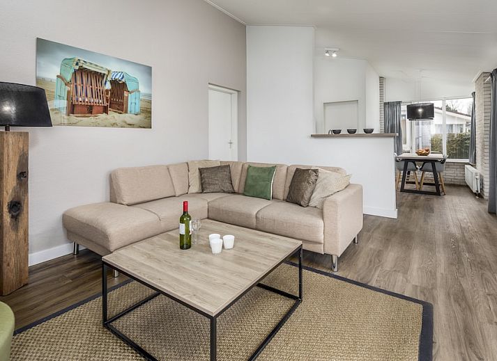 Cozy living room of RG Comfort bungalow in Kamperland, North Beveland with comfortable sofas and garden view.