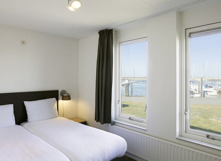 Cozy living room of RG Comfort bungalow in Kamperland, North Beveland with comfortable sofas and garden view.