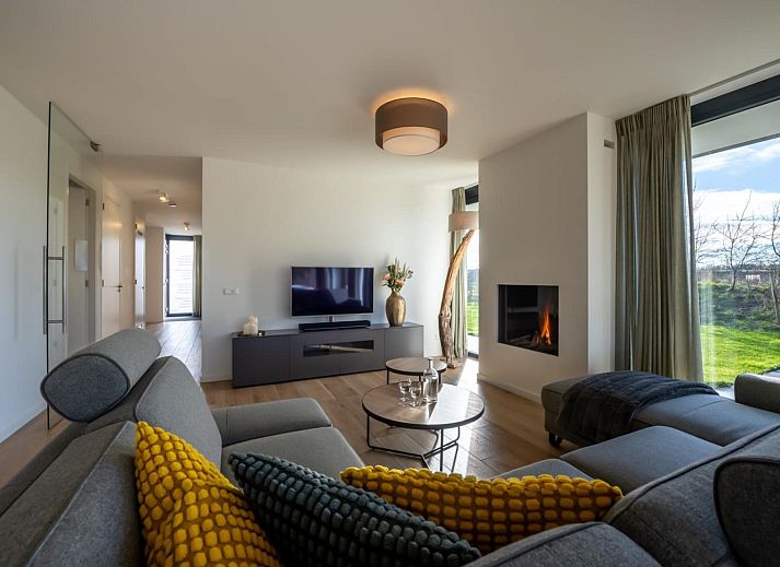 Gezellige woonkamer met open haard in Duinvallei 13, vakantiehuis in Kamperland, Noord-Beveland, Zeeland.