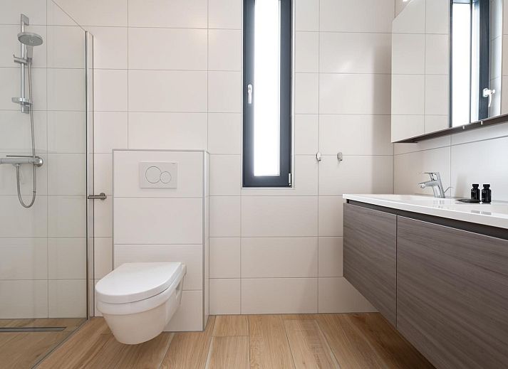 Moderne zithoek met uitzicht op de tuin in Duinvallei 13, vakantiehuis in Kamperland, Noord-Beveland.