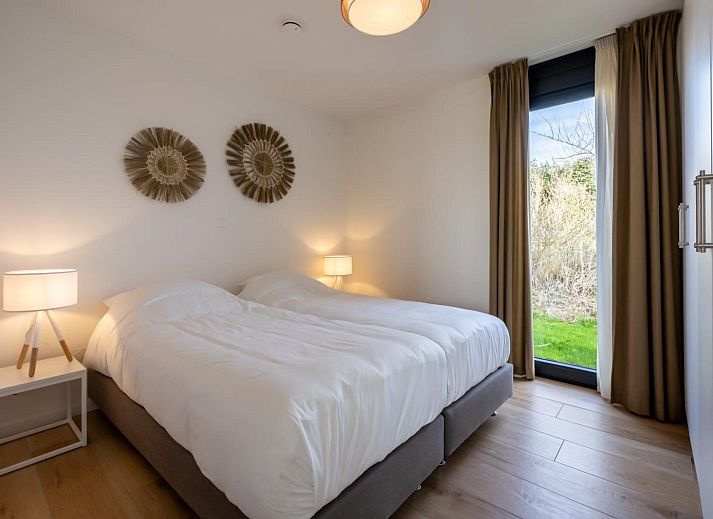 Stijlvolle eetkamer met grote ramen in Duinvallei 13, vakantiewoning in Kamperland, Zeeland.