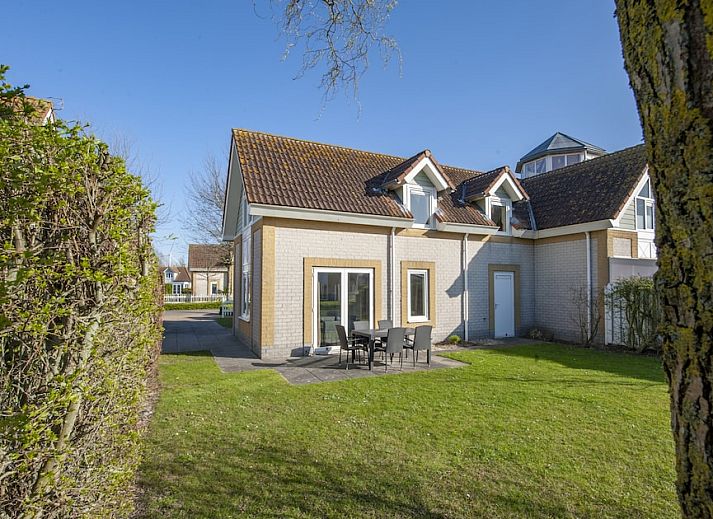 Villa 5B in Kamperland, Noord-Beveland, Zeeland biedt een zonnig terras en groene tuin voor een ontspannen vakantiehuiservaring.
