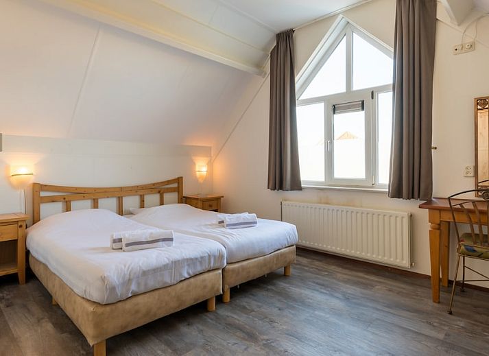 Villa 5B in Kamperland, Noord-Beveland, Zeeland biedt een zonnig terras en groene tuin voor een ontspannen vakantiehuiservaring.