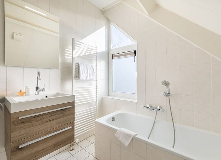 Villa 5B in Kamperland, Noord-Beveland, Zeeland biedt een zonnig terras en groene tuin voor een ontspannen vakantiehuiservaring.