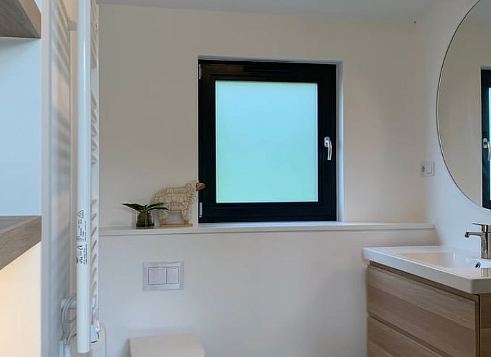 Terrace of vacation home in Kamperland with comfortable chairs and views of green surroundings in North Beveland, Zeeland.