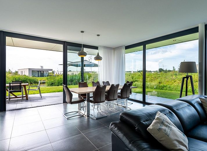 Stilvolles Wohnzimmer in Duinvallei 22, einem Ferienhaus in Kamperland, Noord-Beveland, mit Blick auf die Natur von Zeeland.