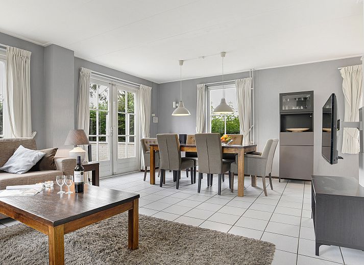 Cozy living room in Villapark Livingstone 4-person villa 4BE, Burgh-Haamstede, with dining area and large windows.