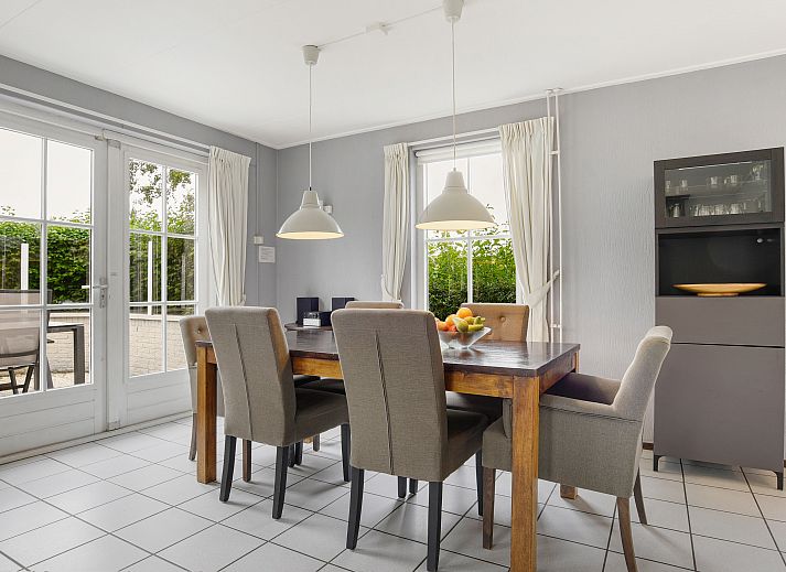 Cozy living room in Villapark Livingstone 4-person villa 4BE, Burgh-Haamstede, with dining area and large windows.