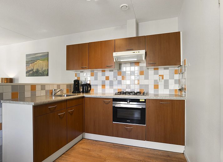 Lichte leefruimte met toegang tot balkon in Residence 't Hof van Haamstede, vakantiehuis in Burgh-Haamstede, Zeeland.