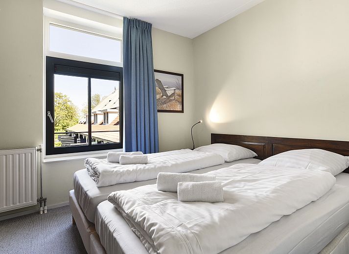 Lichte leefruimte met toegang tot balkon in Residence 't Hof van Haamstede, vakantiehuis in Burgh-Haamstede, Zeeland.